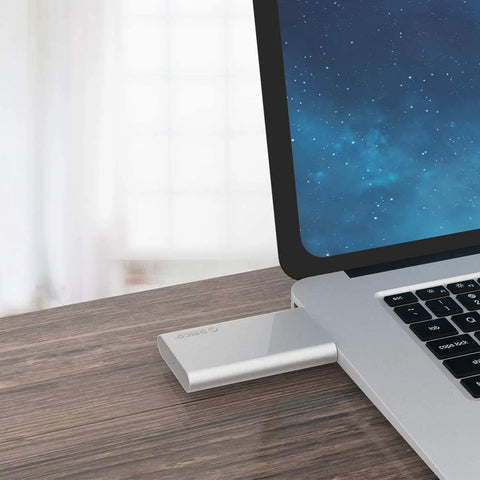 Silver pocket USB 3.0 mSATA enclosure connected to a laptop, showing use of 'Turn Your Spare mSATA Drive Into a Pocket USB 3.0 SSD With No Cable Required, A Grab And Go Enclosure For 30mm And 50mm mSATA, Up To 4TB, 5 Gbps USB External Storage For Laptops And Desktops Not For SATA Mini PCIe'.