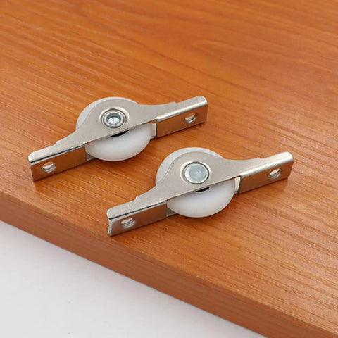 Two metal slider wheels on wood surface, part of 8 Pack Rock Hard Nylon Slider Wheel Replacement Pulleys for Walk in Closets Cabinet and Chiller Doors Smooth Rolling Track Upgrade with Easy Peasy Snap Fit Design Durable Abs Build for Hotel and Restaurant Fixups.