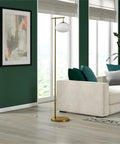 Living room with Go To 68 Inch Tall Arc Floor Lamp With Glass Shade In Brushed Brass And Milk White near cream sofa and art.