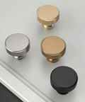 Four knurled cabinet knobs in gold, silver, bronze, and black on a table surface, 10 Pack Gold Knurled Cabinet Knobs For Drawers, Dressers, Cupboards And Wardrobes, Sleek Knurled Handles With Easy Install Mounting, Durable Brass Construction, Modern Kitchen And Bedroom Hardware, Model ZH0036