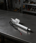 12V Electric Linear Actuator With Straight Push Pull Rod For Heavy Duty Industrial Automation And Sofa Lifts IP65 Waterproof on metal table.