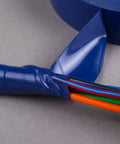 Close-up of blue electrical tape wrapping colorful wires, showcasing insulation application, not the Bulk 48 Roll Carton Electrical Tape.