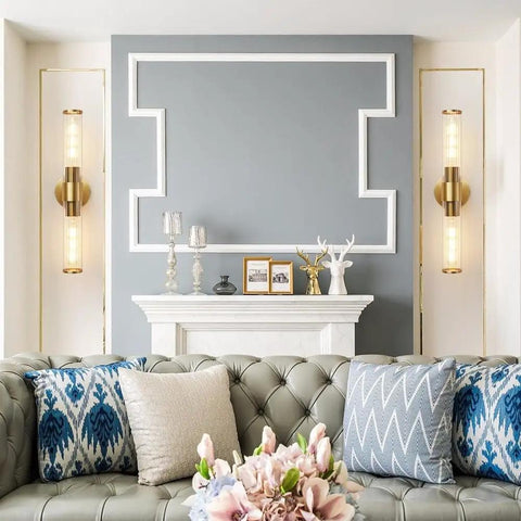 Elegant living room with modern decor and two wall sconces flanking a white fireplace, featuring plush cushions and a tufted sofa.