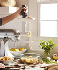 Person using Stand Mixer Food Grinder Attachment for KitchenAid Style Mixers, coarse and fine grinding settings for chickpeas in kitchen.