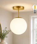 Mid Century Modern Globe Ceiling Light With Frosted Glass Ball And Totally Slick Gold Brass Finish Knockout Semi Flush Mount Fixture Comes With Dimmable E26 Warm Bulb For Hallway Stairs Or Closets in a bright room.
