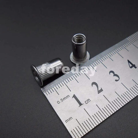 Badass M5 Rivet Insert Clinch Nuts Premium 304 Stainless Steel Flat Head Knurled Blind Hardware Locking Fasteners 20 Piece Pack on a ruler