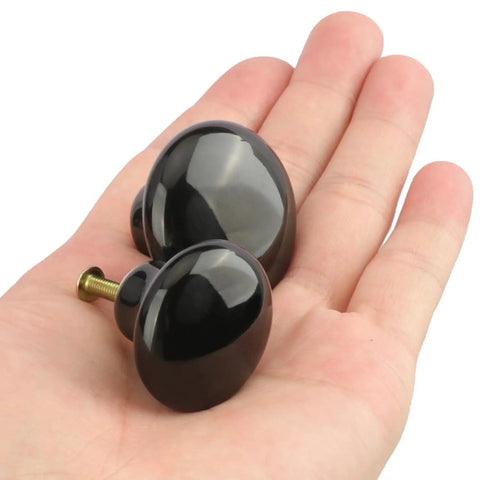 40 Pack Black Ceramic Cabinet Knobs Set With Glossy Mushroom Style Finish, two knobs shown in hand