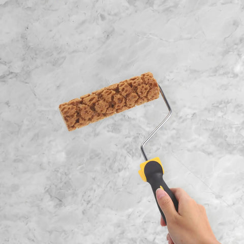 Hand holding a Snazzy Pineapple Textured Sponge Paint Roller against a marble surface for DIY home decor projects.