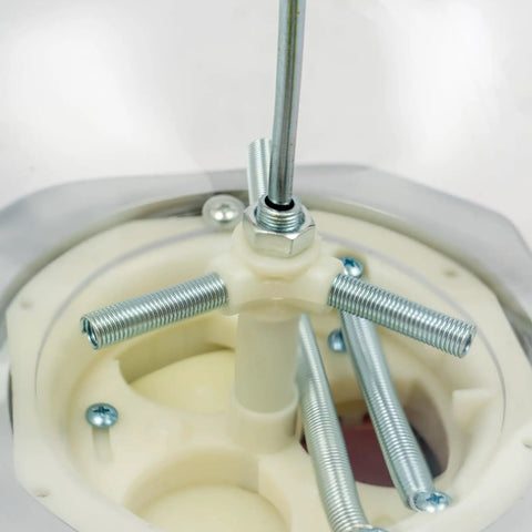 Close-up of the inner mechanics of a Dead On Pink Twister Ball Dispenser with steel screws and white plastic components.