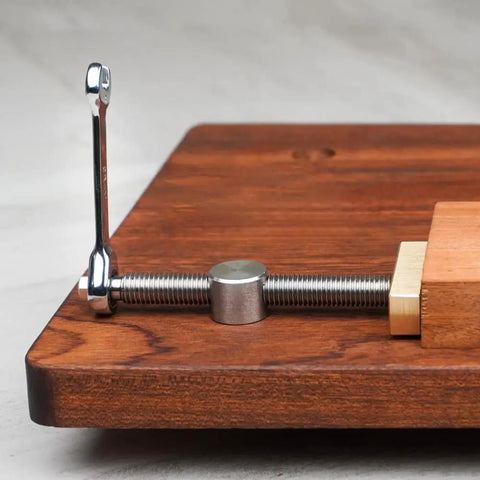 Close-up of Bench Dog Clamp 3/4 Inch Dog Hole Clamp with stainless steel bench dogs installed on a wooden workbench.