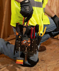 Worker kneeling with Sturdy Leather Tool Pouch With Eleven Pockets For Belt Up To Two And Three Quarters Inches Moisture Resistant