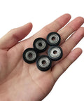 Five Badass U Groove Ball Bearings 5mm Double Shielded Chromium Steel V Track Rollers in hand for precision use.