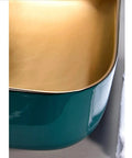Above counter vessel sink in teal porcelain with glossy gold interior, 50X40X13 cm, enhances any bathroom as a smooth operator.