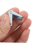 Hand holding a zinc plated steel toggle wing nut for drywall mounting, part of Heavy Duty Zinc Plated Steel Toggle Bolt And Wing Nut Kit For Secure Drywall Mounting, Easy Install, High Load Capacity, 60 Pack For Wall Brackets, Shelves, TVs, And Microwave Mounts.