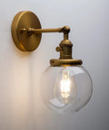 Industrial Style Wall Sconce With Clear Globe Glass Hardwired Vanity Light Off Switch Vintage Farmhouse Loft Bedroom Lighting Fixture For Homes 110 120 Volt Max 40W E26 Base Ready For Bathroom Vanity Or Hallway Use, shown mounted on a wall with clear glass shade revealing bulb