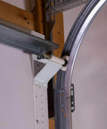Installed heavy duty 2mm steel garage door track rails with R12 radius curved design, horizontal tracks for 7 foot high doors.