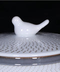 Close-up of the bird-shaped lid of the ceramic rice bucket with a blue and white glaze, ideal for keeping staples fresh.