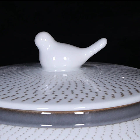 Close-up of the bird-shaped lid of the ceramic rice bucket with a blue and white glaze, ideal for keeping staples fresh.