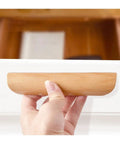 Hand holding Wooden Cabinet Drawer Pull Handles For Wardrobes And Furniture Knobs With Natural Wood Grain Finish Easy Install