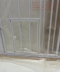Close-up of Extra Tall Expandable Dog Gate for Doorways and Bottom of Stairs featuring a small pet door, white metal material.