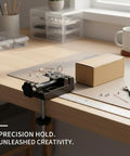 This Mini Aluminum Alloy Bench Vise Is A Compact Clamp Perfect For Jewelry Making And Precision Crafts on a workspace holding small components.