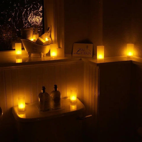 Rechargeable Tealights Flickering Flameless Candles With Charging Base creating cozy mood in dim bathroom setting