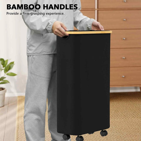 Person holding a black Slim Laundry Hamper With Wheels And Lid, 62L Rolling Clothes Basket with a bamboo handle, narrow design.