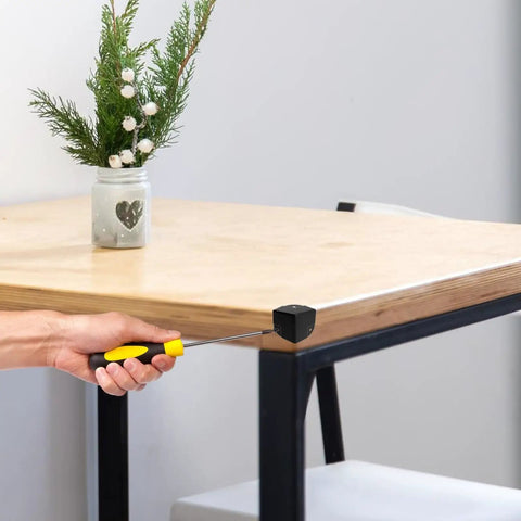 16 Pack Real Deal Metal Corner Protectors For Cabinets And Boxes Chrome Plated Heavy Duty Edge Guards With No Sweat Install Hardware Included Top Shelf Protection For Your Gear shown being installed on a wooden table corner.