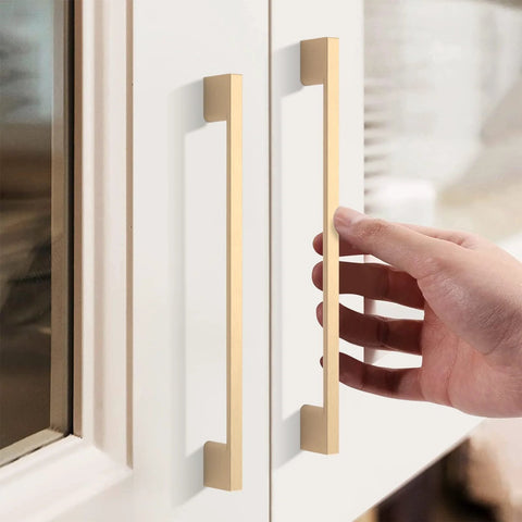 Hand reaching for 10 Pack Brushed Brass Cabinet Pulls With 7 Point Five Inch Hole Centers Zinc Alloy Gold Tone Hardware