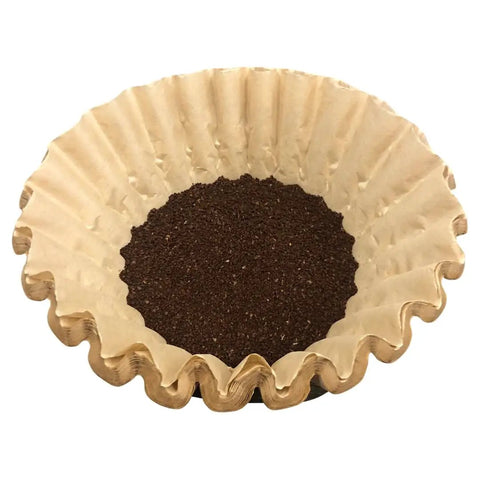 Natural Unbleached Brown Biodegradable Extra Large Coffee Filters For 10 To 15 Cup Baskets filled with coffee grounds.