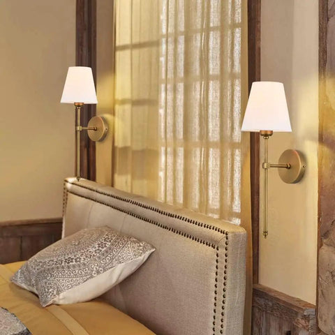 Two Pack Hardwired Brushed Brass Wall Sconces With Fabric Shade, mounted above a bed, modern classic lighting in a bedroom
