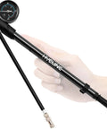 High Pressure Shock Pump With Gauge For Bike Suspension Up To 300 PSI, compact mini pump in hand, showing gauge and valve