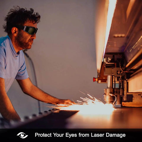 Dubofu laser safety goggles with black frame and dark lenses, worn by man beside a laser engraver emitting sparks