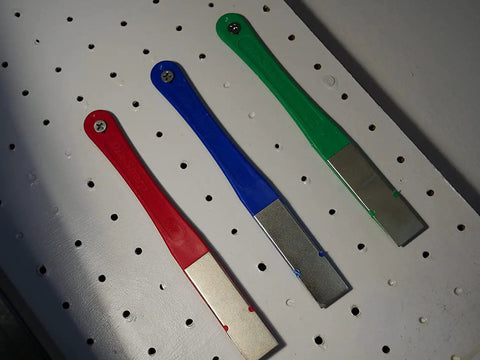 Three DiaSharp Diamond Mini Hone Sharpening Kit stones with coarse, fine, and extra fine grit on a white perforated board.