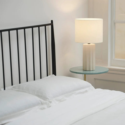 20 Inch Rustic Table Lamp With Ribbed Concrete Base And White Linen Shade on bedside table in modern bedroom setting