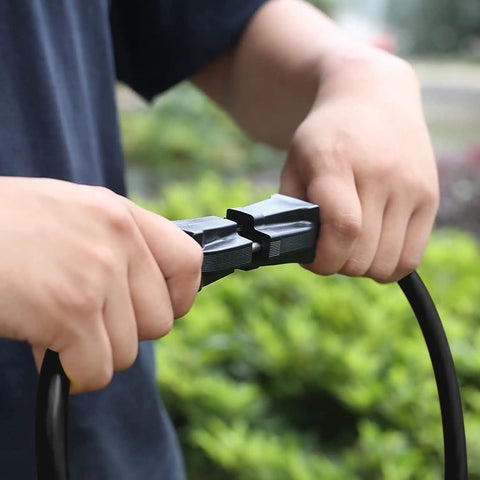Hands holding Workhorse 25 Foot Outdoor Extension Cord With Power Indicator Light 12 Gauge Three Conductor SJTW.