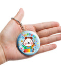 Person holding a cute animal-themed keychain made from Epic 100 Pack Button Maker Kit For DIY Badges 2.25 Inch Metal Shells