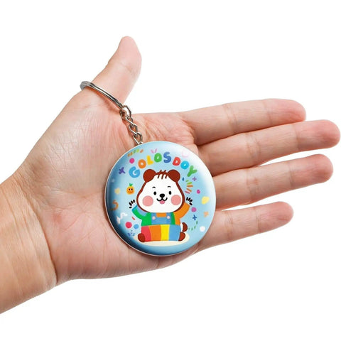 Person holding a cute animal-themed keychain made from Epic 100 Pack Button Maker Kit For DIY Badges 2.25 Inch Metal Shells
