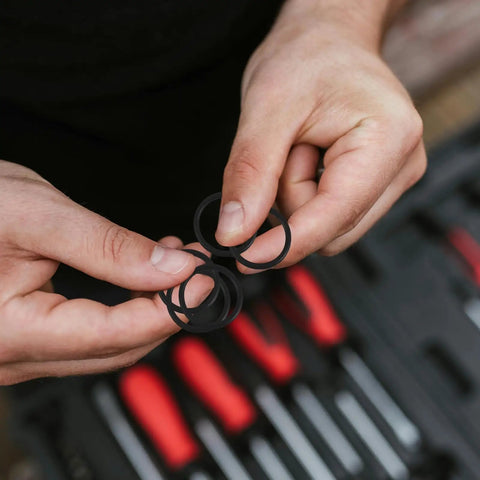Hands holding black rubber sealing rings, Must Have 10 Piece Rubber Sealing Ring Set For Pail Lids And Oil Buckets, Leakproof And Airtight Gasket Replacement For Farm And Job Site Use, Easy To Install Spare Part, Durable Rubber Seal Keeps Liquids Contained.