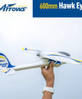 Person holding Arrows RC Plane 600mm Hawk Eyes Remote Control Airplane Ready to Fly RTF, white with blue and yellow accents