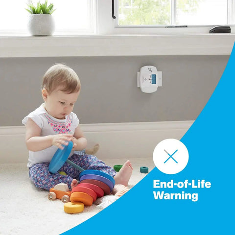 Child playing next to Dual Power Plug In Carbon Monoxide Detector with Battery Backup and Digital Display installed on wall.