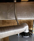 Fiberglass Heat Shield Tape With Aluminum Backing applied on industrial exhaust pipes for 2000°F protection against heat and chemicals.
