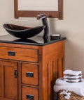 Cascade Waterfall Vessel Faucet With Single Lever Handle, Oil Rubbed Bronze Finish, on wooden vanity with vessel sink.