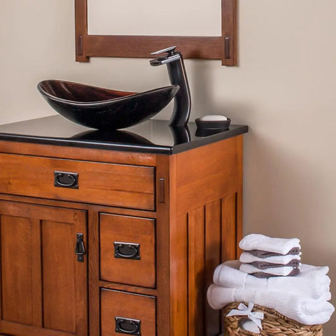 Cascade Waterfall Vessel Faucet With Single Lever Handle, Oil Rubbed Bronze Finish, on wooden vanity with vessel sink.