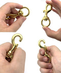 Top Shelf Heavy Duty Brass Flag Clips 4 Pack Swivel Snap Hooks For Rope Flagpole Attachment Built Tough showing brass hooks in hand.