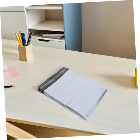 Stack of Self-Seal White Poly Mailer Bags 100 Pack 10x14 Inches Waterproof And Tear-Resistant on desktop