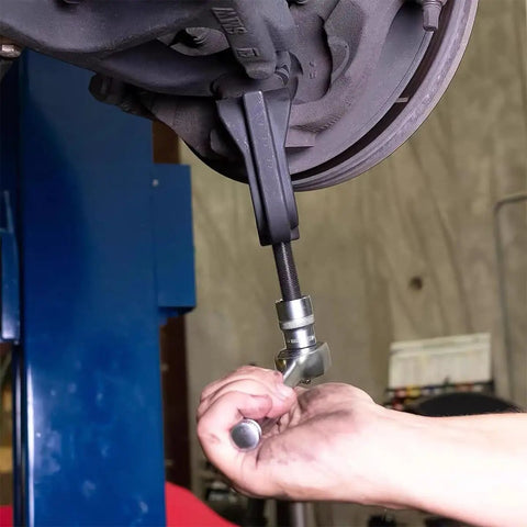 Heavy Duty Ball Joint Separator And Removal Tool Giving You Two Point Three Eighths Inch Extension For No Sweat Suspension Work On Daily Drivers Classic Rides Pickup Trucks SuVs in use removing a pivot point.