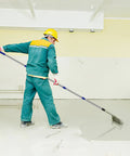 Worker using 20-inch spiked screeding roller for epoxy flooring with 2m detachable pole, achieving smooth finish.