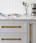 2 Pack 3-1/2 Inch Center to Center Antique Brass Cabinet Pulls installed on kitchen drawers, durable aluminum or stainless steel construction.