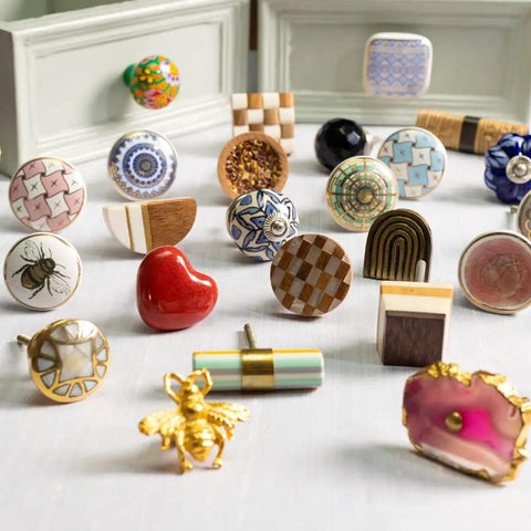 Assorted decorative dresser knobs and handles on display, showing various designs and materials.